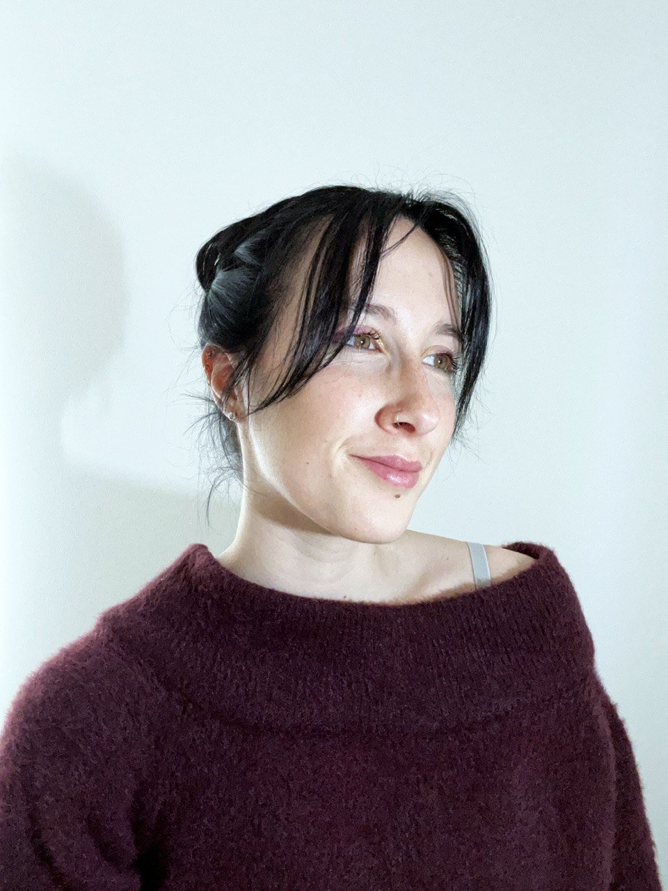 Portrait of Rebecca Guerrini wearing a burgundy sweater and looking to the side